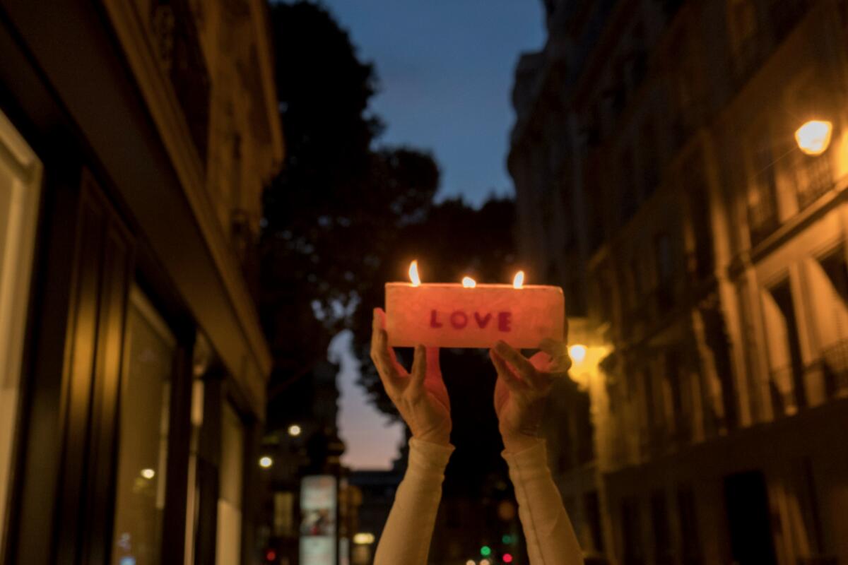 Hands holding a glowing LOVE candle at Glow Candle Lounge
